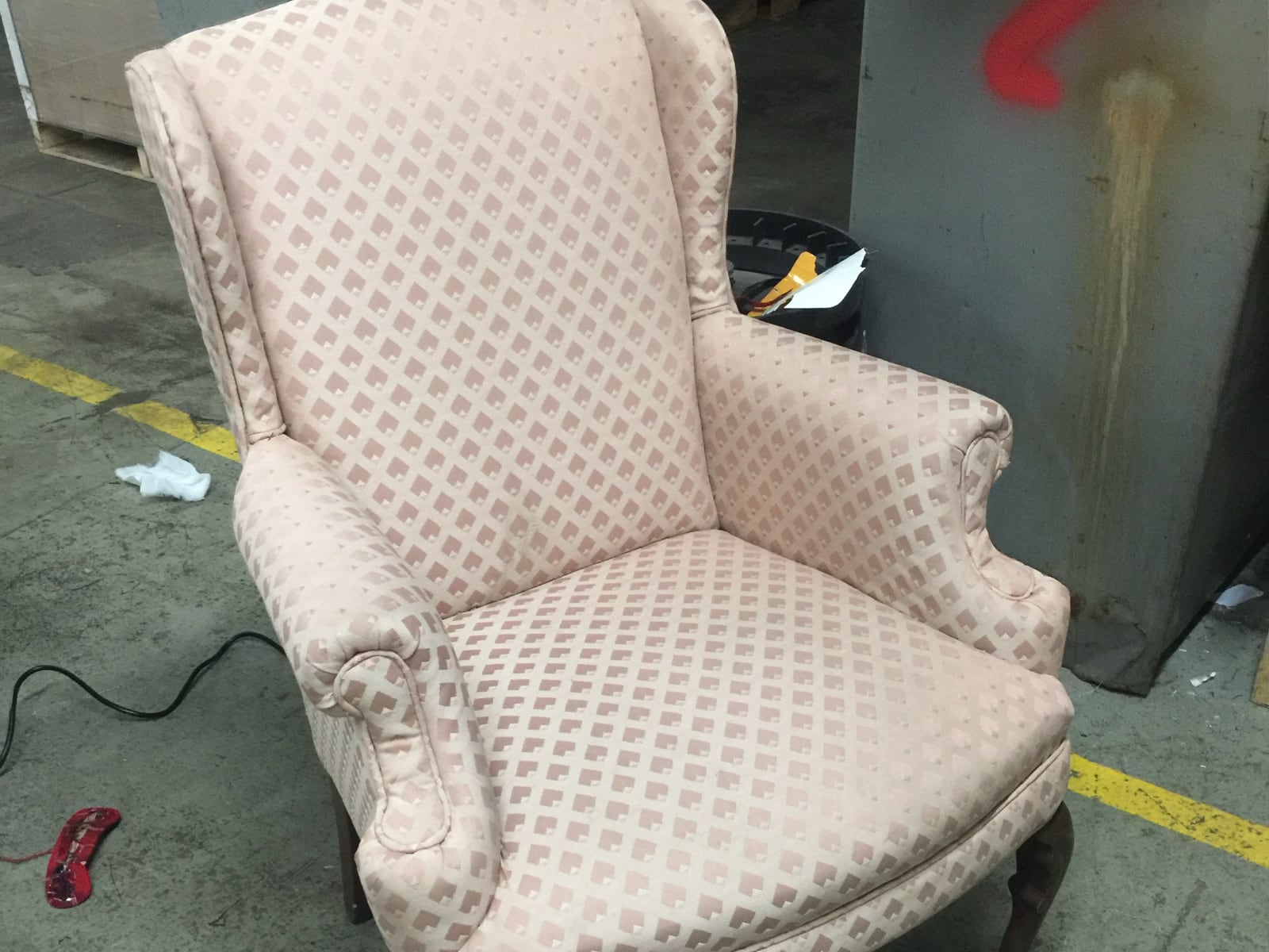 Wingback chair in its original pink diamond-pattern cover
