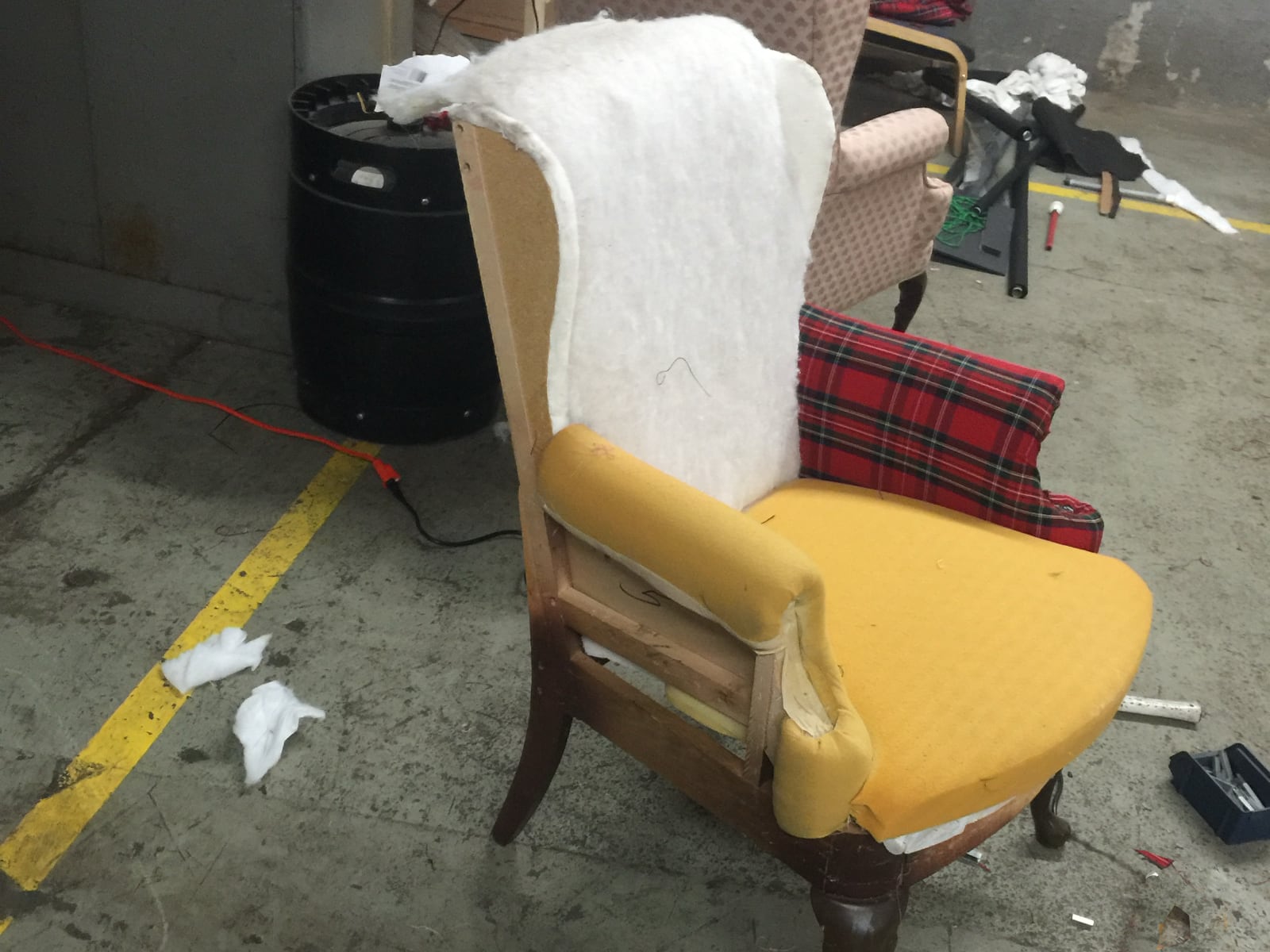 Chair stripped down, with new batting on the back and plaid going onto the arm